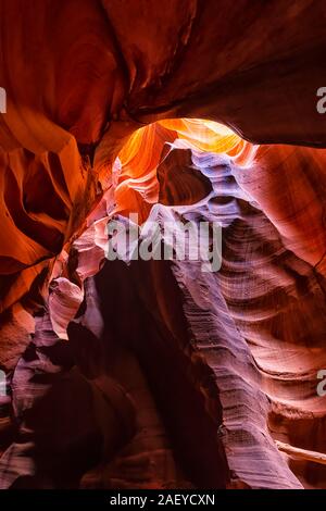 Wide angle vertical view of shadows and light at upper Antelope slot canyon with wave shape abstract formations of red orange rock layers sandstone in Stock Photo