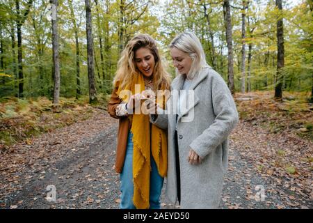 Women watching a streaming video in a remote forest on a smartphone