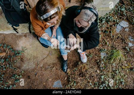 Women streaming video on their smartphone in a remote forest Stock Photo