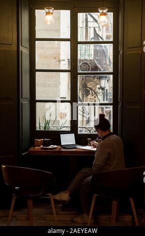 Young student is studying in a coffee shop with her laptop Stock Photo