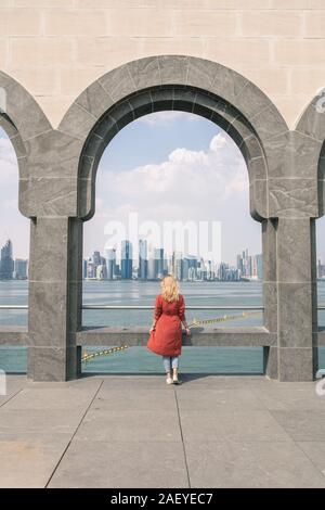 Woman standing under the museum arch and looking at the sea Stock Photo