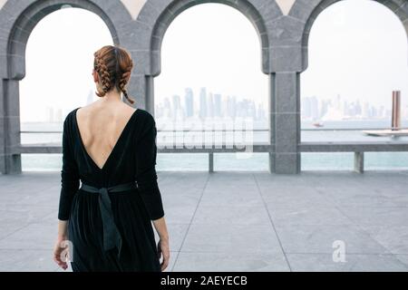 Back view of young woman standing near archs in Museum of Islamic art Stock Photo