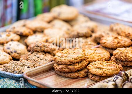 Many different cookies on trays display in street food farmers market or bakery cafe with raisin oatmeal and sugar biscuits Stock Photo