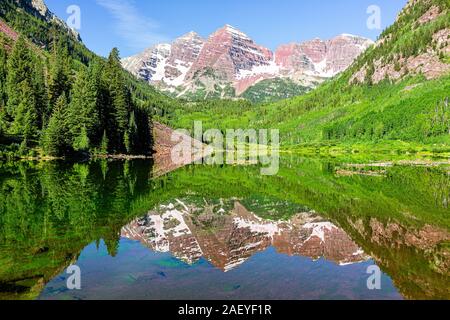 Maroon Bells lake mirror reflection during day view in Aspen, Colorado with rocky mountain peak in July 2019 summer