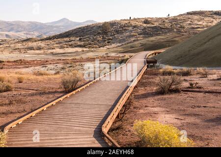 Tourists make the Painted Cove Trail in Painted Hills at sunset Stock Photo