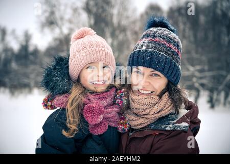 Mother and daughter playing in winter park Stock Photo
