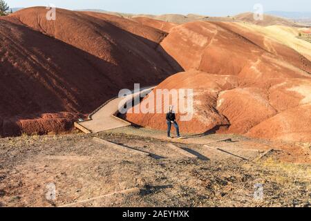 A young woman passes by the wooden walkway at Painted Cove Trail in Painted Hills Stock Photo
