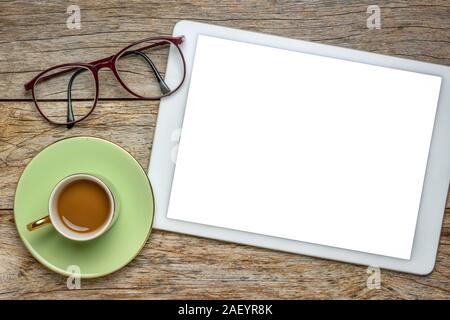 desktop flat lay - digital tablet with white screen, cup of coffee and glasses against rustic wood, office concept Stock Photo