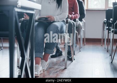 Students seating on the chairs. Group of people at business conference in modern classroom at daytime Stock Photo