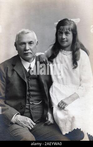 Vintage photograph of a grandfather and his granddaughter circa 1910. Stock Photo
