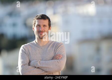 Front view portrait of a serious adult man posing looking at camera standing outdoors in a rural town Stock Photo