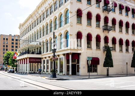 Little Rock, USA - June 4, 2019: Capital hotel sign on building in Arkansas city and empty street with flowers and flags Stock Photo