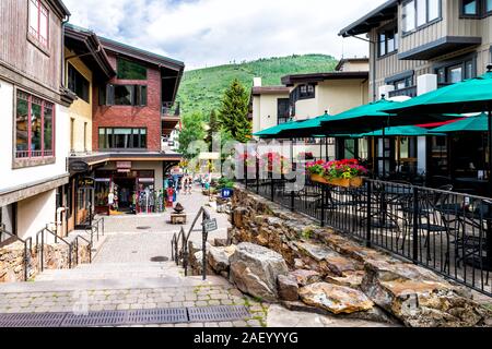 Vail, USA - June 29, 2019: Swiss style ski resort town in Colorado with shops restaurants on Gore Creek drive steps down Stock Photo