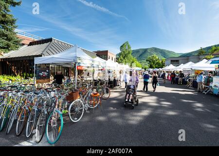 Aspen, USA - July 6, 2019: Vendors selling vintage bicycles at stall stand in farmers market with people walking in outdoor summer street Stock Photo