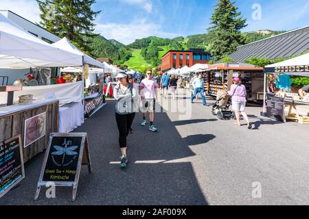 Aspen, USA - July 6, 2019: Vendors selling greent tea kombucha at stall stand in farmers market with people walking in outdoor summer street Stock Photo