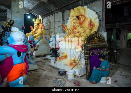 A clay artist gives finishing touches to an idol of Hindu deity Lord ...