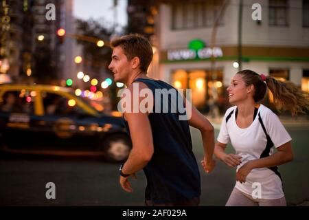 Young couple jogging on city street. Stock Photo