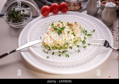 Close-up vegetarian lasagna with spinach and microgreens on a white plate. Tasty and healthy mediterranean food. Stock Photo