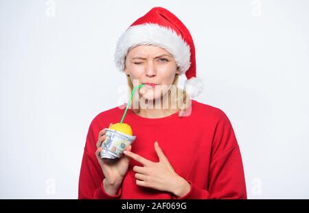 Girl santa hat drink juice lemon wrapped in banknote. Totally natural lemonade. Girl with lemonade and money. Fresh lemonade drink with straw. Symbol of wealth and richness. Christmas lemonade punch. Stock Photo