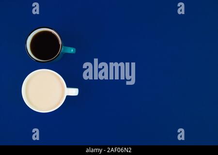 Two cups with different kinds of coffee on a blue background with empty space, minimalistic composition with hot beverages, top view. Stock Photo