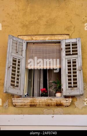 Old, open window with shutters and red flower, historic town of Rovinj, Istria, Croatia Stock Photo