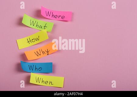 Questions - Why? What? Where? When? Why? How? on colorful stickers on pink backround Stock Photo