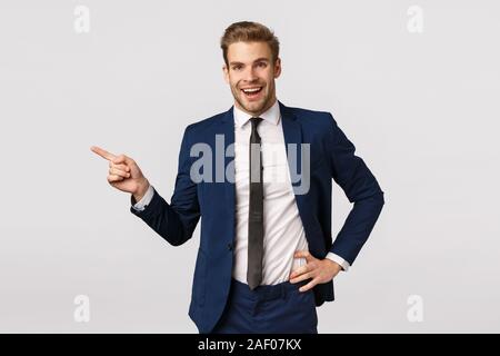 Business, corporate and entrepreneur concept. Handsome cheerful blond bearded businessman in suit, talking to coworkers, smiling happy and relieved Stock Photo