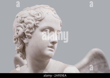 side view portrait of a classical angel face white sculpture marble on grey background Stock Photo