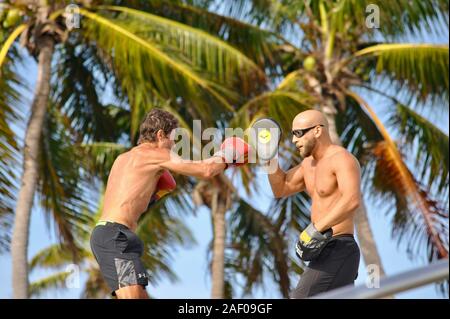 A middle age, fit, male boxer training with muscular personal trainer coach outside in a park in Miami Beach, Florida, USA Stock Photo