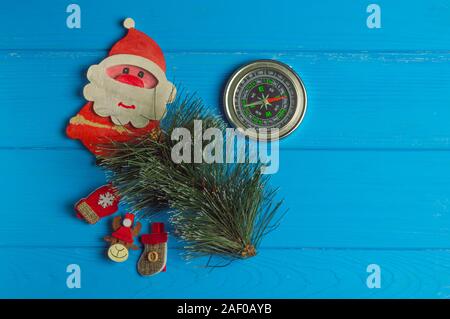 Compass points where Santa lives: compass and Christmas figurines are on blue background Stock Photo