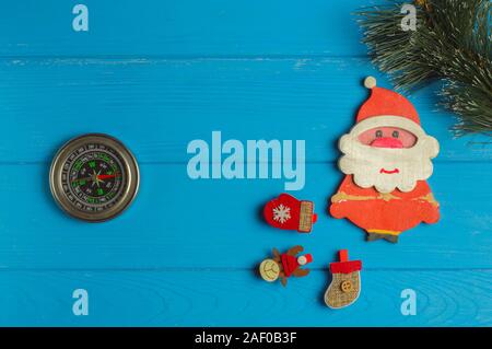 Compass points where Santa lives: compass and Christmas figurines are on blue background Stock Photo