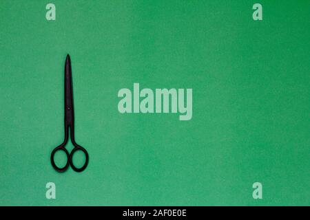 Single old soviet scissors isolated on green background Stock Photo