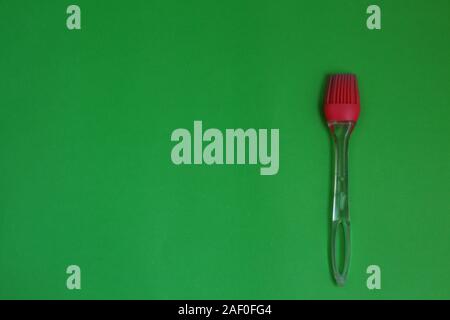 Red kitchen silicone brush on a green background Stock Photo