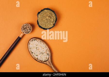 Different types of uses for hemp. Seeds, protein and powder in wooden spoons. Stock Photo