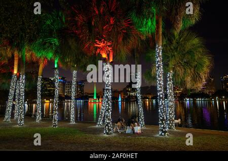 People picnic next to holiday lights in Lake Eola Park, Orlando, Florida. Stock Photo