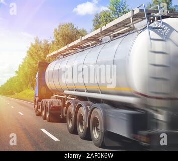 big gas-tank truck goes on highway against the sky Stock Photo