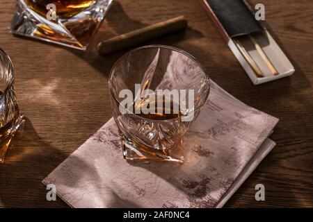 Brandy in glasses with map, cigar and matches on wooden table Stock Photo