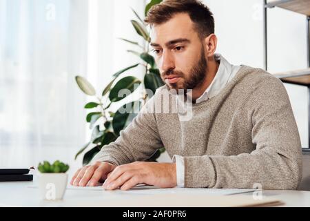 Blind man reading braille font at table Stock Photo