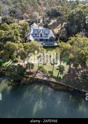 Aerial view of large waterfront luxury home on wooded lot. Stock Photo