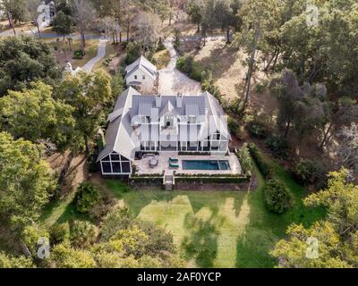 Aerial view of beautiful large home with pool on wooded lot. Stock Photo