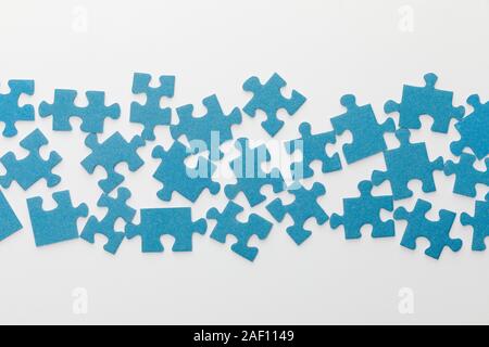 top view of scattered pieces of blue jigsaw puzzle on white background Stock Photo