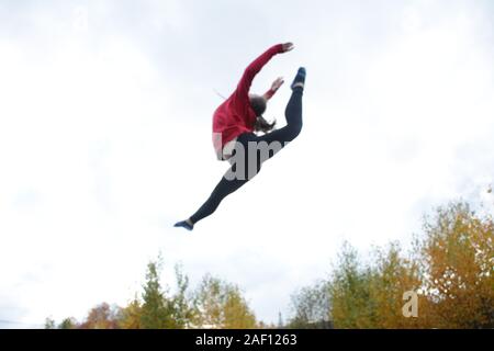 Teenage girl doing acrobatics on trampoline Stock Photo