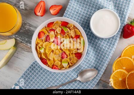 Healthy breakfast cornflakes and strawberries with milk, yogurt and orange juice. Bio healthy. Close up Stock Photo