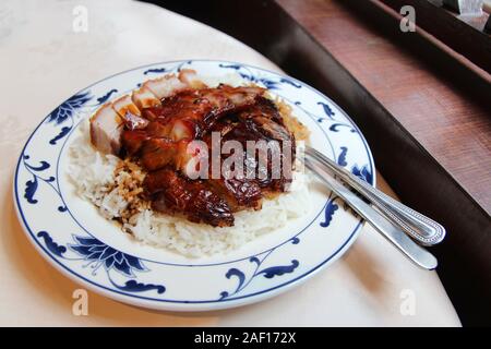 Roast duck, roast pork (char siu) and crispy pork belly (siu yuk) with rice in a Chinese restaurant Stock Photo