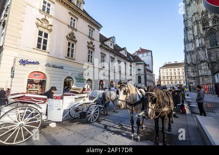 VIENNA, AUSTRIA - NOVEMBER 6, 2019: Fiaker, typical horse drawn carriages, standing in front of the Stephansplatz in downtown Vienna. These horse cabs Stock Photo