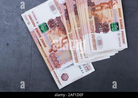 Big stack of Russian money banknotes of five thousand rubles lying on a grey cement background Stock Photo