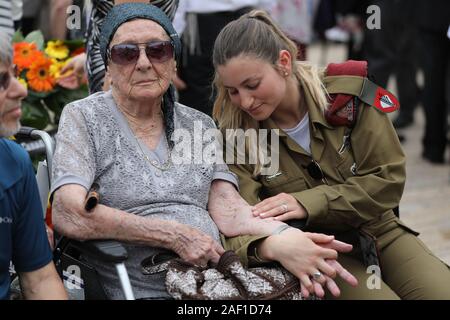 Jerusalem, Israel. 12th Dec, 2019. Israeli soldier Shira Tessler holds the hand of her grandmother, Holocaust survivor Hanna Tessler during a ceremony marking the annual Holocaust Remembrance Day at Yad Vashem Holocaust Memorial in Jerusalem, Israel, on May 2, 2019. Israel comes to a complete standstill across the country as the siren sounds honoring the six million Jews who perished at the hands of the Nazis during the Holocaust of World War II. Pool Photo by Abir Sultan/UPI Credit: UPI/Alamy Live News Stock Photo