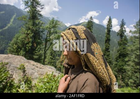 Pahalgam, Jammu and Kashmir, India - August 02, 2011: Profile portrait of gypsy woman of Gujjar ethnicity with eyes closed and hand on chest Stock Photo