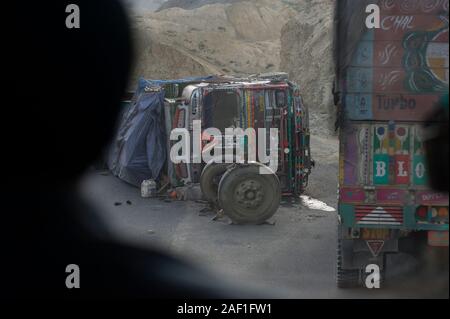 Leh, Jammu and Kashmir, India - July 30, 2011: Bus driver watches overturned truck on Leh-Manali Highway Stock Photo