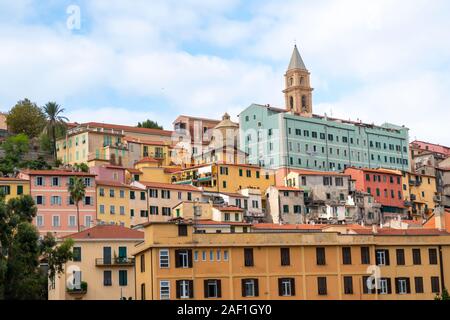 Colorful residential buildings are stacked on a hillside underneath the Ventimiglia Cathedral in the seaside town of Ventimiglia, Italy. Stock Photo